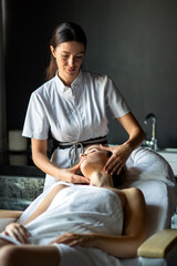 Wall Mural - Beautiful happy relaxed woman enjoying professional wellness massage in spa salon