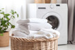 Stack of clean bedding sheets on blurred laundry room background