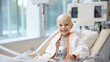 A portrait of a bald young patient boy smiling in a cancer hospital bed in a medical care hospice bald after course chemotherapy. Children with cancer concept