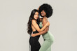 Beauty asian woman posing with her friend with afro hairstyle. Cheerful, elegant girls standing together, looking at the camera and smiling happily