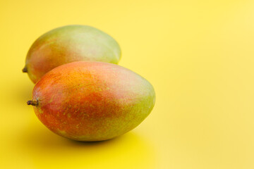 Sticker - Ripe mango fruit on yellow background.