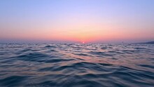 View From The Surface Of The Sea At Sunset. Chilling On The Sea Waves And Watching The Setting Sun Go Below The Horizon