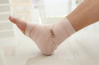 Man with ankle sprain elastic bandage for ankle injury and feeling pain
