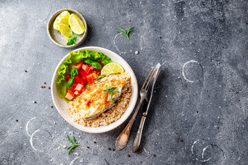 Wall Mural - Fried catfish steak with rice and vegetable salad on a gray background top view