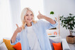 © deagreez - Portrait of nice feedback good job symbol mature aged businesswoman thumbs up likes her new office with living room interior indoors
