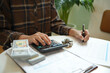 © Charlie's - Saving money. Businessman Accountant verify growing business and saving money stacking coins with calculator. Accountancy Concept