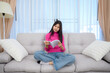 © เลิศลักษณ์ ทิพชัย - Asian teenage girl Reading a book at her home on the cloth sofa in the living room with a nice holiday at home.