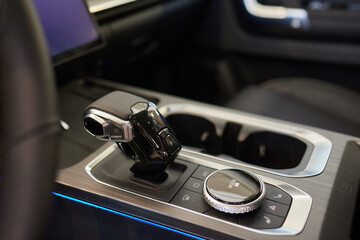 Wall Mural - Selector automatic transmission with leather in the interior of a modern expensive car. The background is blurred. Black and brown leather car.