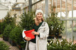 A woman buying a Christmas norman tree in a shop