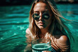Charming blonde woman in sunglasses with glass of water enjoys sea on vacation