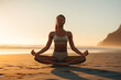 © gankevstock - young African American woman finds tranquility in a meditative yoga pose on the beach, embodying peace and harmony with the surrounding nature