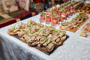 Wall Mural - light snacks for the holiday, catering. Various light snacks. Catering plate. Assortment of sandwiches on the buffet table. meat, fish, vegetable canapes.