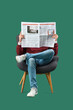 © Pixel-Shot - Young man reading newspaper in armchair on green background