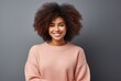 portrait of a curly-haired African American woman wearing a peach fuzz colored sweater