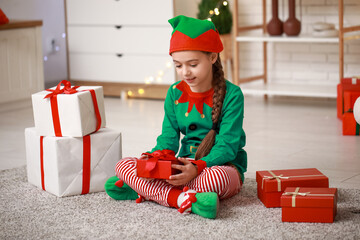 Sticker - Cute little girl in elf costume with gifts at home on Christmas eve