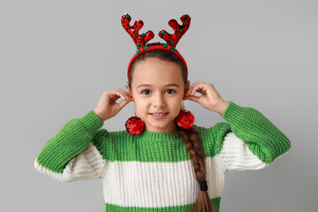 Sticker - Cute little girl in reindeer horns with Christmas balls on grey background