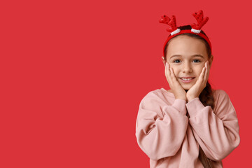 Sticker - Cute little girl in reindeer horns on red background