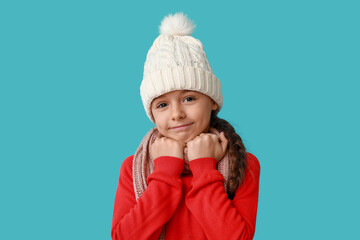 Sticker - Cute little girl in warm hat and scarf on blue background