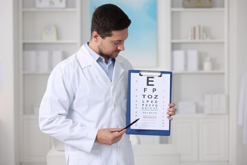 Wall Mural - Ophthalmologist pointing at vision test chart in clinic