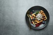 Delicious Belgian waffle with ice cream, berries and chocolate sauce on grey textured table, top view. Space for text