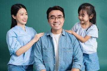 Wall Mural - Photo of young Asian family on background