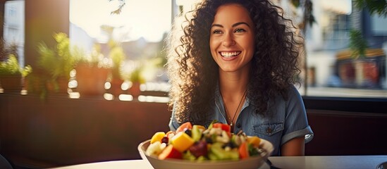 Cheerful female tourist enjoying fruit salad at outdoor restaurant terrace in summery surroundings