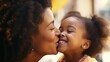 Close-up of a beautiful daughter kissing her mother on the cheek. Young African girl kisses happy mother Cute black girl kisses cheerful woman
