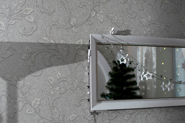 Wall Mural - A mirror decorated with a garland and a reflection of a Christmas tree	