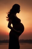 Fototapeta  - Artistic rendering of a pregnant silhouette against a sunset, highlighting the silhouette of the baby bump