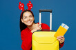 Traveler woman wears red Christmas sweater hold passport ticket bag isolated on plain blue background. Tourist travel abroad in free time rest getaway. Air flight trip Happy New Year holiday concept.