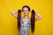 proper long hair care in summer, teen girl make ponytails on yellow studio background. no split ends hair