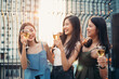 Group of Asian girls holding bottle of beer smiling and dancing at the party restaurant. Friends gathering at the event New Year or birthday concept. Clubbing and lifestyle