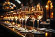 Row of champagne glasses on a table at a luxury event, with warm, elegant lighting in the background.