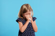 © New Africa - Suffering from allergy. Little girl with tissue sneezing on light blue background