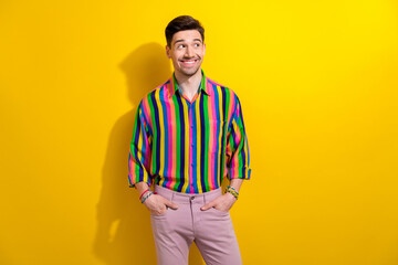 Sticker - Portrait of young happy guy thinking looking empty space curious choosing new outfit for nightclub isolated on yellow color background