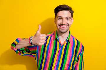 Sticker - Portrait of positive guy in striped shirt thumb up symbol recommend follow his blog about man healthcare isolated on yellow color background