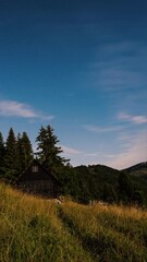 Wall Mural - vertical panorama of day to night time lapse with clouds and stars of milky way galaxy motion over f
