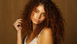 © Gstudio - Beautiful woman with curly brown hair looking at camera generated by AI