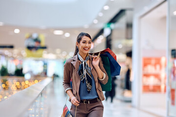 Wall Mural - Cheerful woman spending her day in shopping at mall.