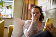© Marko Geber - Concerned woman using smartphone at home