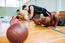 Young People Doing Pushups And Exercising In An Indoor Basketball Gym
