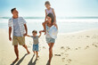 © Grady Reese/peopleimages.com - Parents, children and beach for summer travel vacation, ocean sunshine or sibling together. Man, woman and kid piggy back on sand for family holiday or outdoor clean air, sea relax or love nature