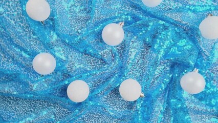 Wall Mural - Christmas light blue background. Glass Christmas bauble on shiny sequin fabric. Slow motion. New Year decoration