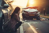 Fototapeta  - A female motorist has a car accident asking for roadside assistance or an insurance company standing on the road after a car accident.