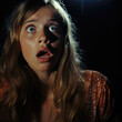 © J S - Cinematic fear image of a scared girl with terrified and shocked face expression in the dark, 1970s vintage horror movie scene with copy space