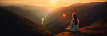 Young woman sitting on a ledge of a mountain and enjoying the beautiful sunset over a wide valley. 