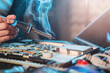 Close-up of a hand repairman specialist man repairs, and repairing electronics in a hardware repair shop