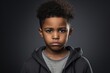 Serious african american boy isolated on dark grey background.