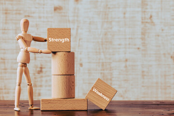 Poster - There is wood cube with the word Strength or Weakness. It is as an eye-catching image.