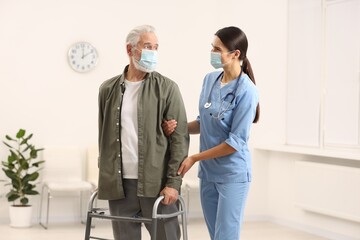 Canvas Print - Young nurse supporting elderly patient in hospital